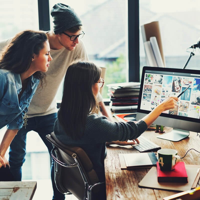 People collaborating at a computer desk.